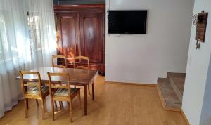 une salle à manger avec une table, des chaises et une télévision dans l'établissement Ferienwohnung Ruhequell, à Königsfeld im Schwarzwald