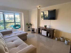 Sala de estar con 2 sofás y TV en Condominio Puerto Pacífico, (Coraceros), Viña, en Viña del Mar