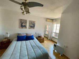 1 dormitorio con 1 cama azul y ventilador de techo en Precioso apartamento junto al centro con garaje en Valencia