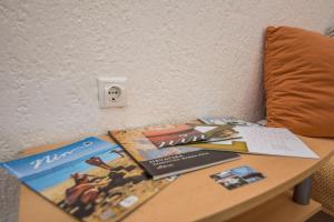 una mesa con libros y revistas encima de una cama en Apartment Emina, en Batalaži