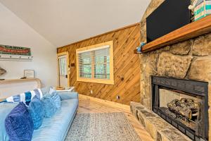 a living room with a stone fireplace and a blue couch at The Falls in Hood