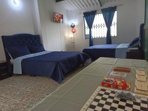 een slaapkamer met 2 bedden en een speelgoedtrein op een tafel bij Yinkana Casa Campestre in Guatavita