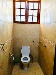 a small bathroom with a toilet and a window at Kilimanjaro Pazuri Villas in Moshi