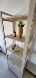 Un estante en una cocina con un jarrón. en Departamento Temporario 54, en La Plata 5 fotos más