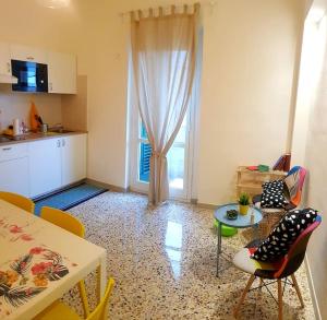 a living room with a table and chairs and a kitchen at La Casina di Isola in Livorno