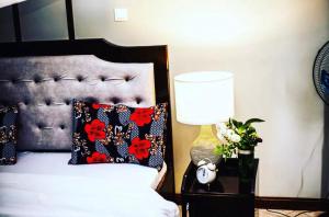 a bedroom with a bed with a lamp and flowers at Kilimanjaro Pazuri Villas in Moshi