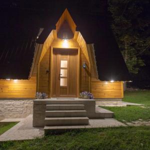 Cabaña de madera pequeña con luz por la noche en Vila Sun forest, en Žabljak