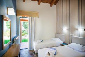 a hotel room with two beds and a window at Villa Givera in Giannoudi