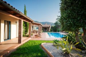 a backyard with a swimming pool and a house at Villa Givera in Giannoudi