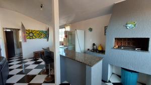 uma cozinha com piso em xadrez preto e branco em Cobertura a 200m da Praia de Ponta das Canas em Florianópolis