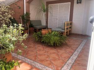 a patio with two chairs and potted plants at Familia anfitriona acoge in Seville