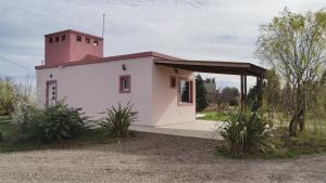 ein kleines weißes Gebäude mit einem Turm darüber in der Unterkunft Las Condalias in Puerto Madryn