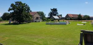 une grande pelouse avec une maison en arrière-plan dans l'établissement Gites Le Grand Tornage, à Évaux-les-Bains