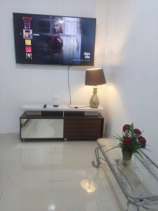 ein Wohnzimmer mit einem TV und einem Tisch mit einer Lampe in der Unterkunft Departamento familiar en cdla privada in Guayaquil