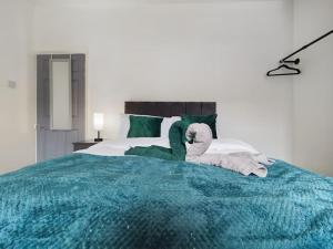1 dormitorio con 1 cama con toallas en Birks House By RMR Accommodations - NEW - Sleeps 8 - Modern - Parking, en Stoke on Trent