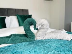 kilka ręczników na łóżku w obiekcie Birks House By RMR Accommodations - NEW - Sleeps 8 - Modern - Parking w mieście Stoke-on-Trent