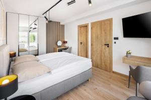 a bedroom with a large bed and a tv at VILA Apartments Piešťany Family Terrace in Piešťany