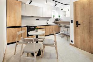 a kitchen with a small table and chairs in a room at VILA Apartments Piešťany Family Terrace in Piešťany