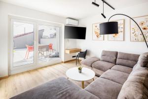 a living room with a couch and a table at VI&LA - Apart House in Piešťany