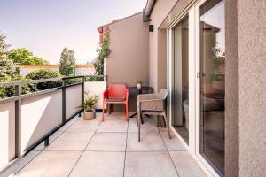 a balcony with two chairs and a table at VI&LA - Apart House in Piešťany