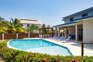 - une piscine avec des chaises et une maison dans l'établissement South Gull Villa - Brand New Ocean Front, à Riversdale