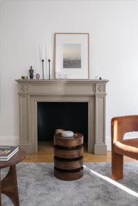 a living room with a fireplace and a chair at Generously large 1 bedroom apartment in Farringdon in London