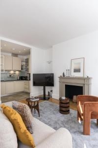 a living room with a couch and a fireplace at Generously large 1 bedroom apartment in Farringdon in London