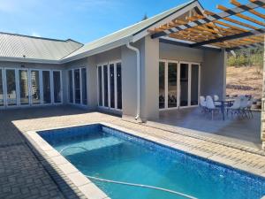 une maison avec une piscine et une terrasse dans l'établissement Villa 206 Clarens Golf Estate, à Clarens