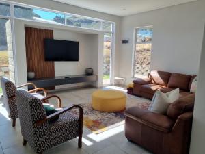 - un salon avec un canapé et une télévision dans l'établissement Villa 206 Clarens Golf Estate, à Clarens