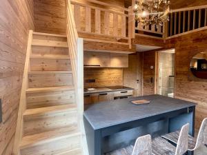 a kitchen with a blue table and wooden walls at Chalet moderne 4 pers avec terrasse, mezzanine et parking - FR-1-505-186 in Crest-Voland +10 photos