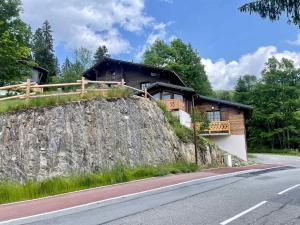 a house on a hill next to a road at Chalet moderne 4 pers avec terrasse, mezzanine et parking - FR-1-505-186 in Crest-Voland