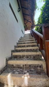 un conjunto de escaleras de piedra con barandilla de madera en El Leon Feliz Palomino, en Palomino