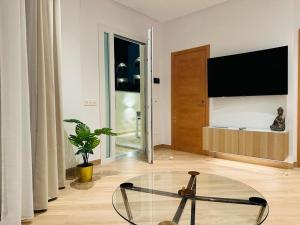una mesa de cristal en una habitación con TV en Atlantis Home PUERTO MARINA - 1 Minuto de la Playa, en Benalmadena Costa