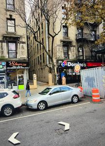 dos autos estacionados en un estacionamiento en una calle de la ciudad en Ysabel, en Nueva York