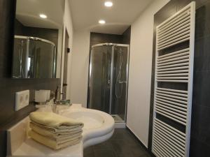 a bathroom with a sink and a shower and a toilet at Hotel & Ristorante Positano in Radeburg +30 photos