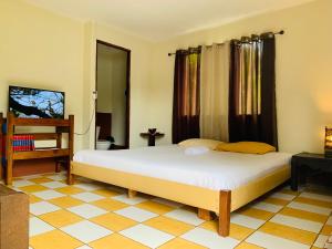 a bedroom with a large white bed in a room at Cabina Rainforest , Valle Azul - Near Fortuna Arenal Volcano in San Lorenzo