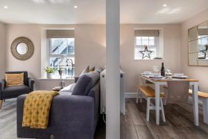a living room with a blue couch and a table at Seagrass Cottage - Aberdovey in Aberdyfi