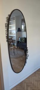 a mirror on a wall with a living room at Signe Home in Gdańsk