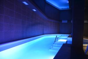 a swimming pool with blue lights in a room at Hotel Spa Acevi Val d’Aran in Vielha