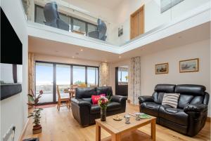 a living room with two leather couches and a table at Bodwennol - A Stunning House! in Aberdyfi