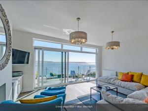 a living room with a couch and a view of the ocean at Glan Y Mor in Aberdyfi