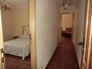 um corredor que leva a um quarto com uma cama em Apartamentos Rurales El Tormagal 