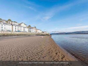 a view of a beach with houses and the water at Pebble Cottage in Aberdyfi