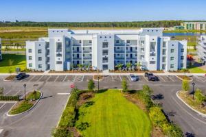 an aerial view of a large white building with a parking lot at Gorgeous Apartment at Storey Lake SL47316 in Kissimmee