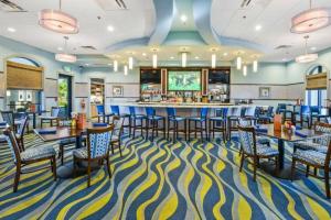 a dining room with a bar and tables and chairs at Modern Vacation Home with Private Pool CG1593 in Davenport