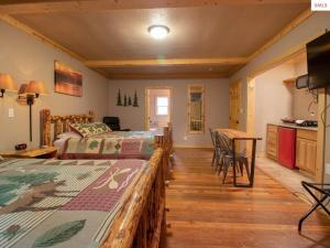 a bedroom with two beds and a table and a kitchen at The Idaho Lodge & RV Park in Bonners Ferry