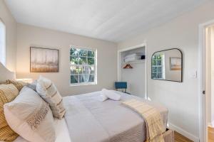 a bedroom with a bed and two windows at Tropical getaway with coastal charm in Pompano Beach