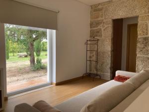 a living room with a couch and a large window at Ar da Beira - Serra da Estrela in Belmonte