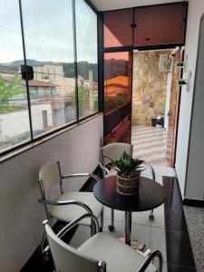 tavolo e sedie in una stanza con finestra di APTO DUPLEX 3 Dorm. em APARECIDA 600 m da basilica a Aparecida