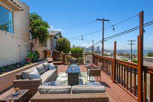 a patio with a couch and chairs on a balcony at Breathtaking Bayview home in San Diego